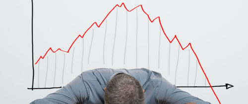 stock-photo-depressed-businessman-leaning-his-head-below-a-bad-stock-market-chart-228094663